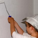 Ökologische Wandfarbe Kind streicht Wand