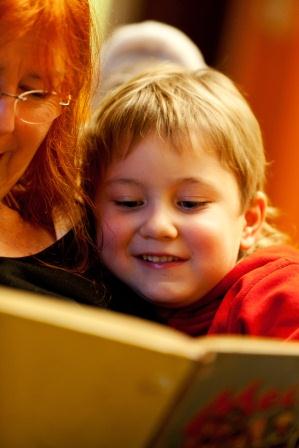 Frau liest Kind aus Buch vor