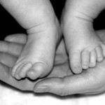Blöder Name- schweres Erbe Babyfüßchen auf Hand