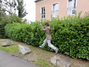 Kind springt über Steine am Linzer Römerberg