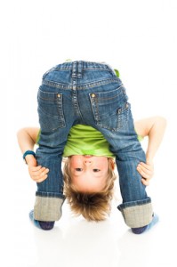 Kind mit Jeans Kind schaut durch seine Beine