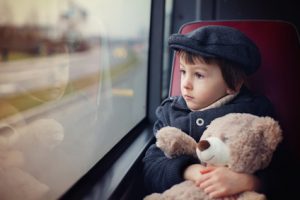 Sweet little child, preschool boy, riding in a bus, daytime, holding teddy bear