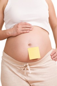 Schwangere mit Notizzettel am Bauch