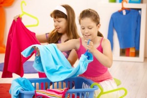zwei Mädchen helfen Wäsche sortieren