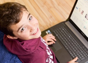 Freundlicher Junge - Kind mit Notebook - Laptop auf dem SchoÃ