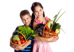 Smiling kids with vegetables in basket