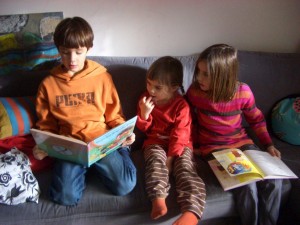 Gemeinsam lesen, Bild Veronike Mayer-Miedl drei Kinder sitzen am Sofa und lesen