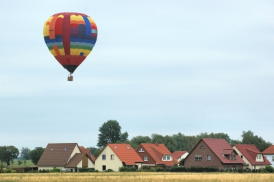Ein Heißluftballon schwebt über Häuserdächern