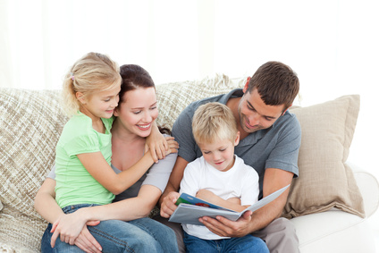 Familie am Sofa liest gemeinsam